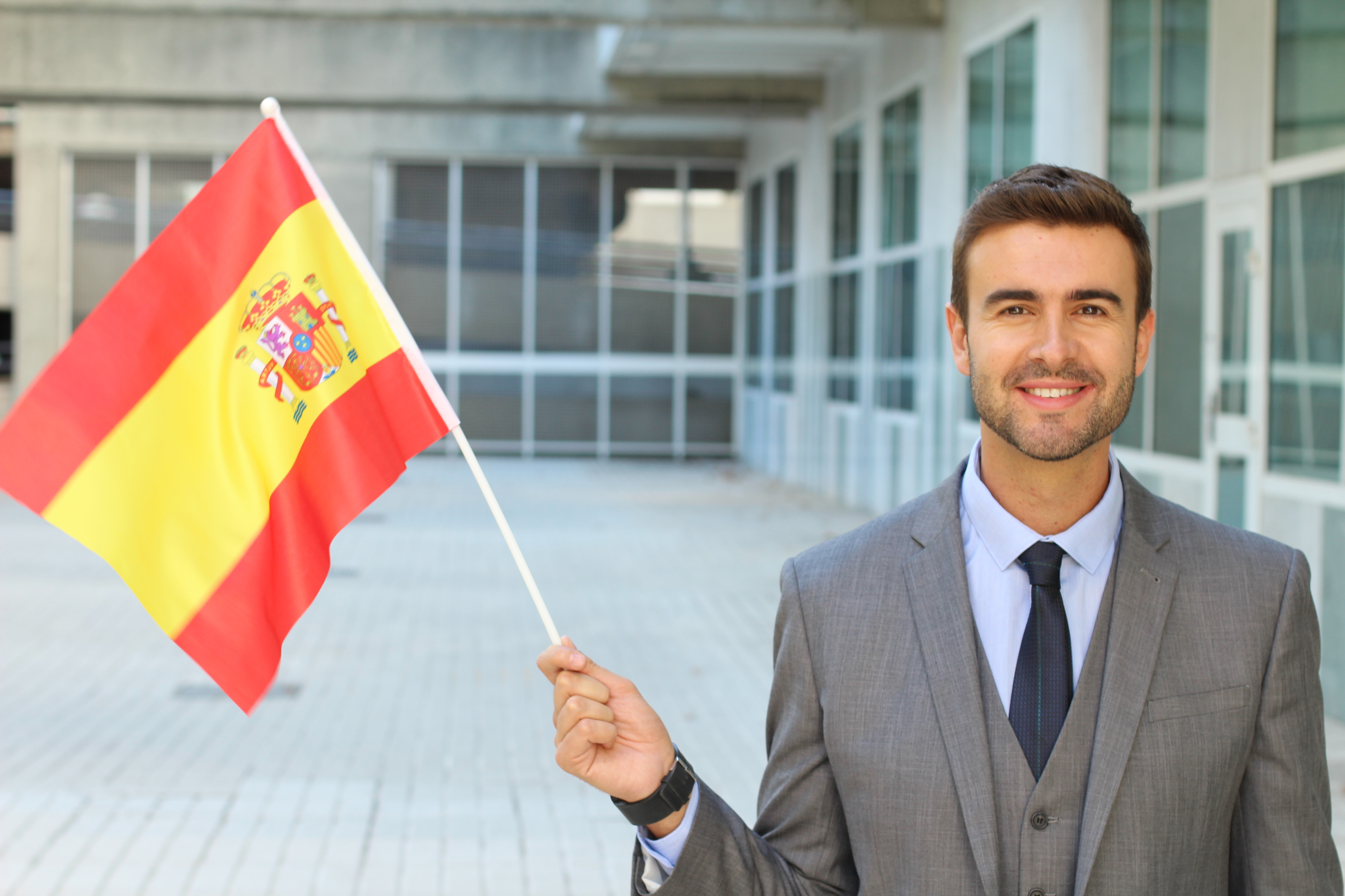 Бизнесмен с флагом Испании, где он может получить визу, как предприниматель