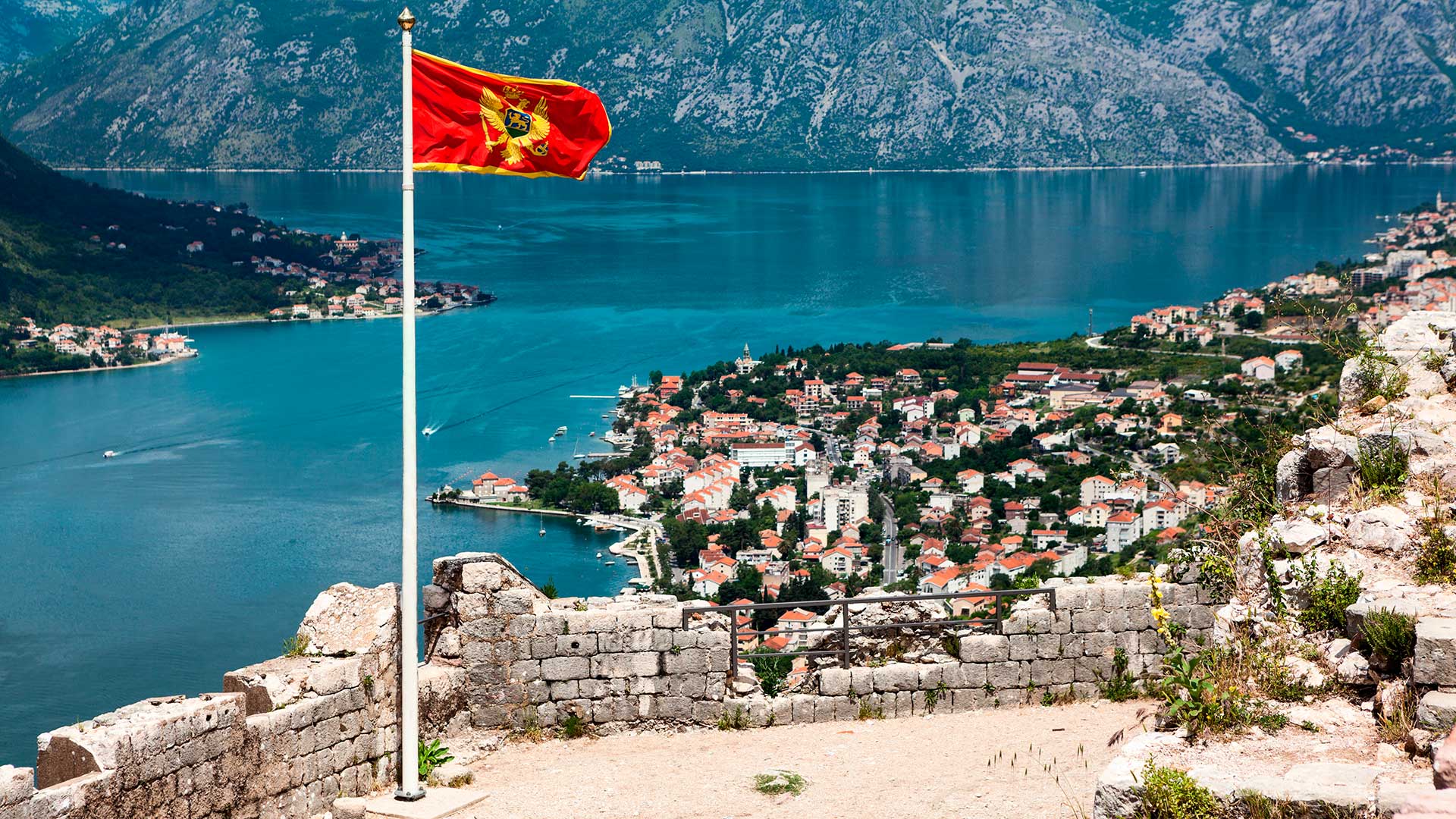 Флаг на фоне Черногории, где можно получить гражданство через инвестиции