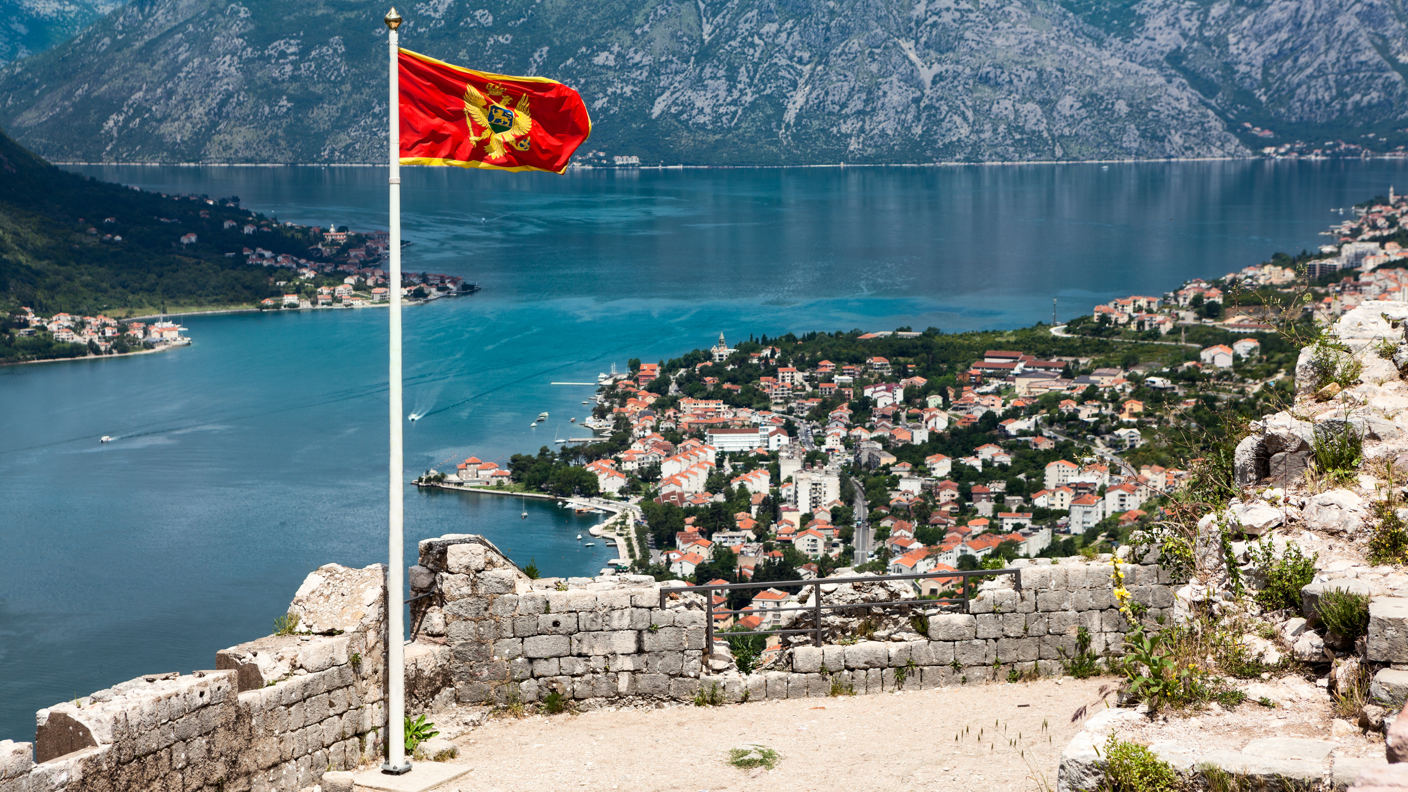 Флаг на фоне Черногории, где можно получить гражданство через инвестиции