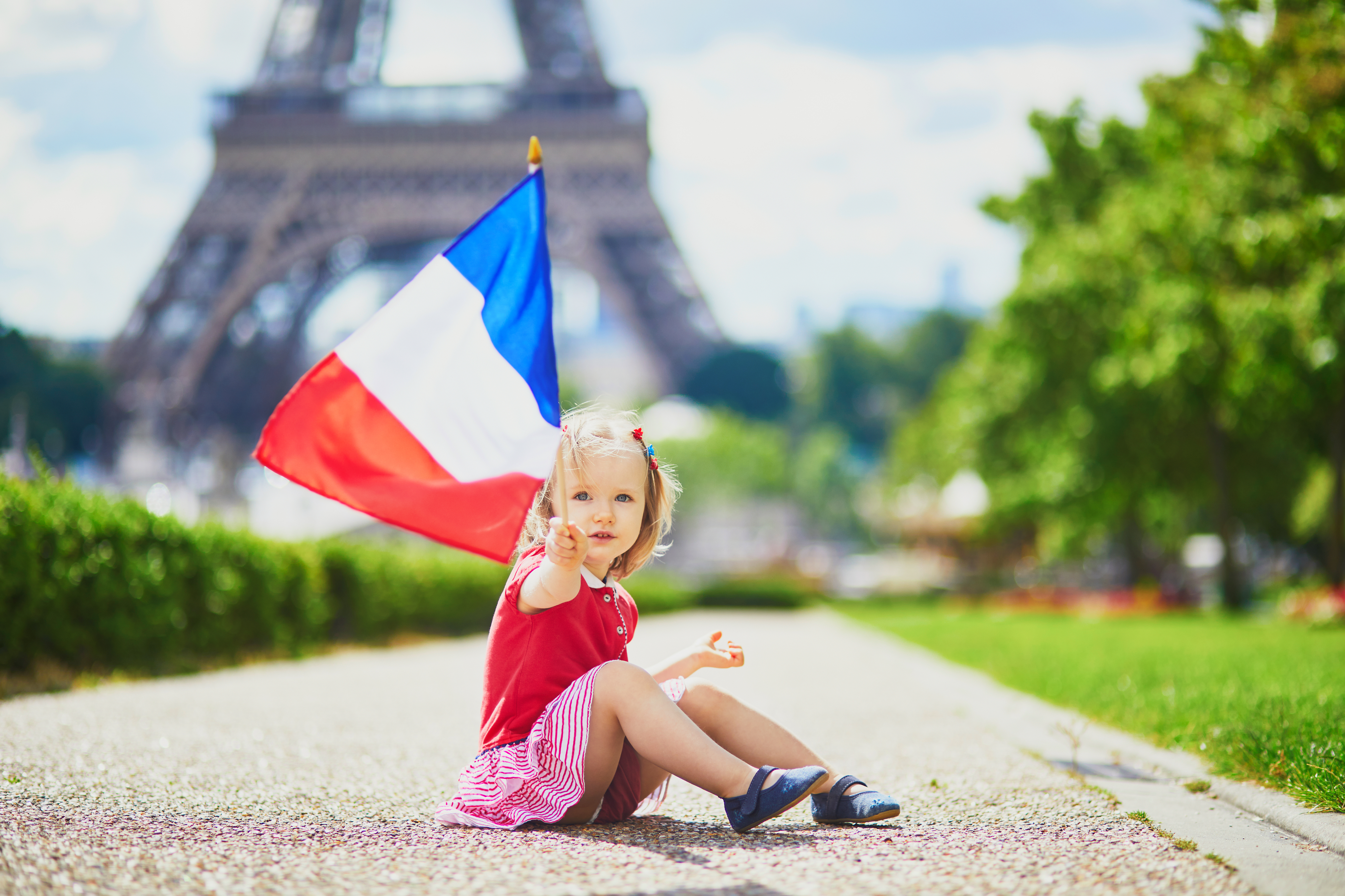 Ребенок с флагом Франции, где он может получить гражданство по рождению