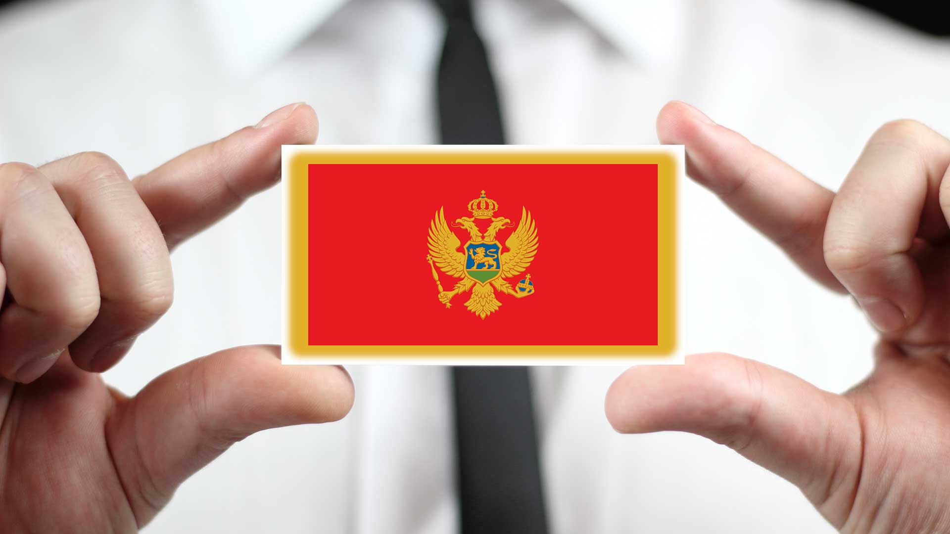 Бизнес-иммигрант держит флаг Черногории, получить ВНЖ которой можно через открытие фирмы
